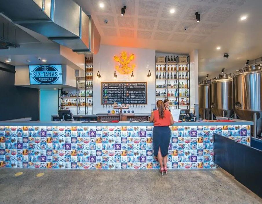 A Woman is Standing at a Counter in a Restaurant — Northern Tile Gallery in Winnellie, NT