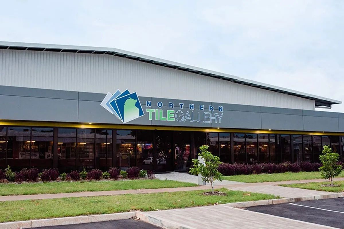 A Large Building With a Lot of Windows and a Lot of Grass in Front of It — Northern Tile Gallery in Winnellie, NT