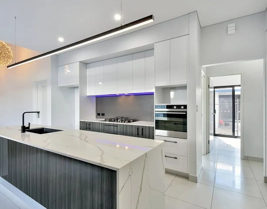 A Kitchen With White Cabinets and a Large Island — Northern Tile Gallery in Winnellie, NT