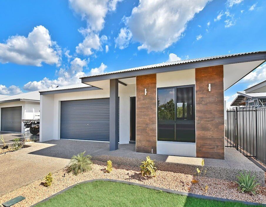 A Modern House With a Large Garage and a Fence in Front of It — Northern Tile Gallery in Winnellie, NT