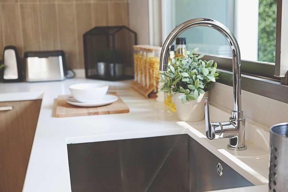 A Kitchen Sink With a Faucet and a Potted Plant on the Counter — Northern Tile Gallery in Winnellie, NT