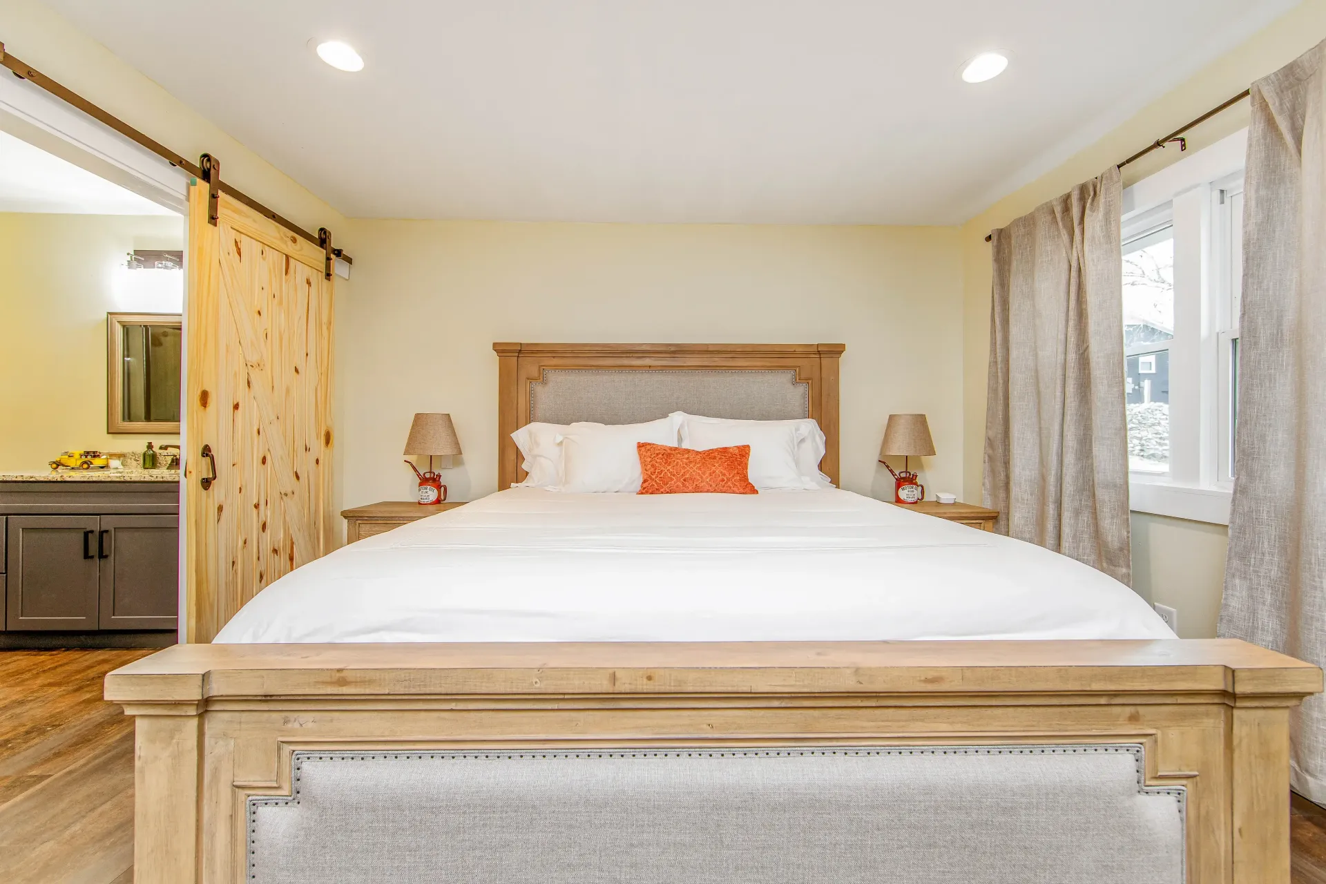 A bedroom with a king size bed and a sliding barn door.