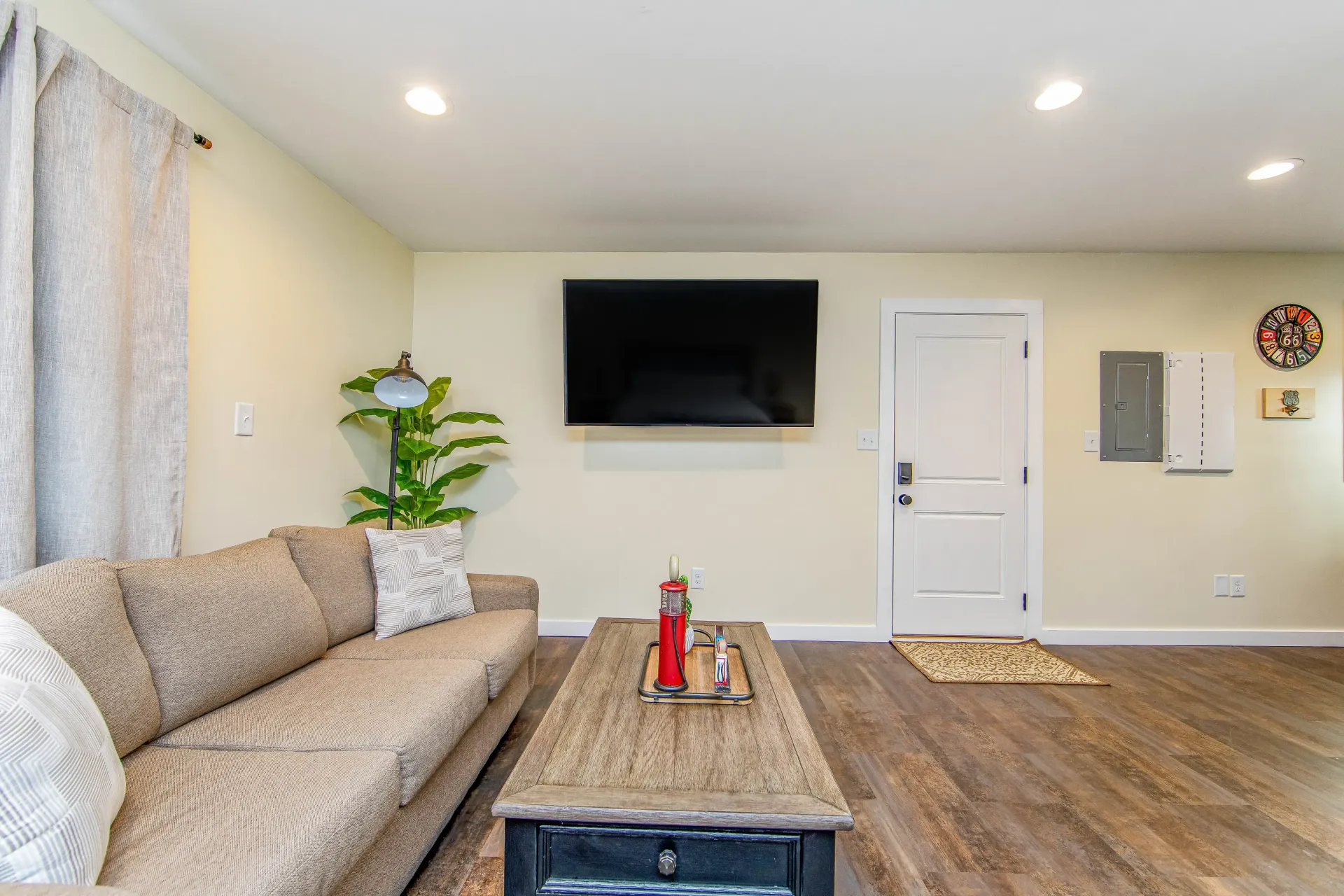 A living room with a couch , coffee table , and flat screen tv.