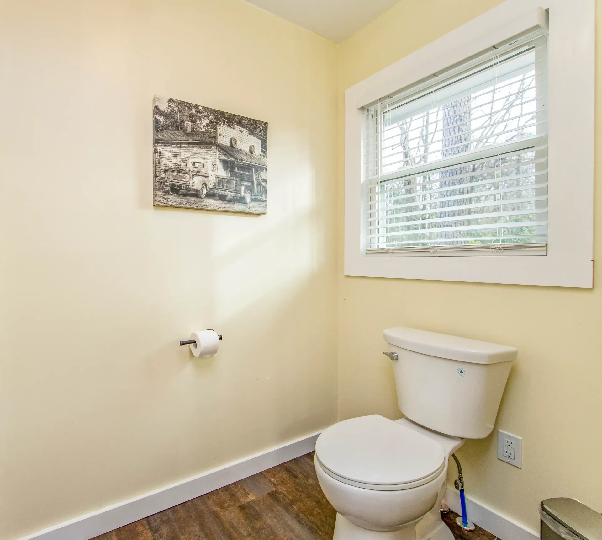 A bathroom with a toilet and a window with blinds