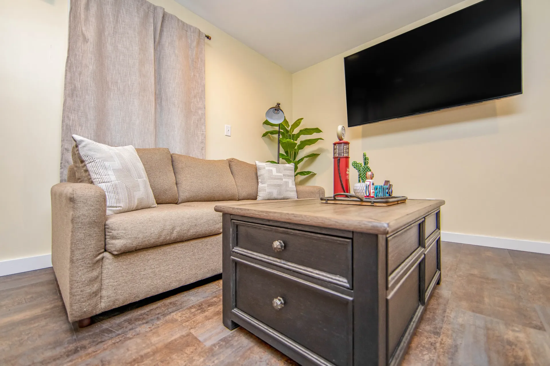 A living room with a couch , coffee table , and flat screen tv.