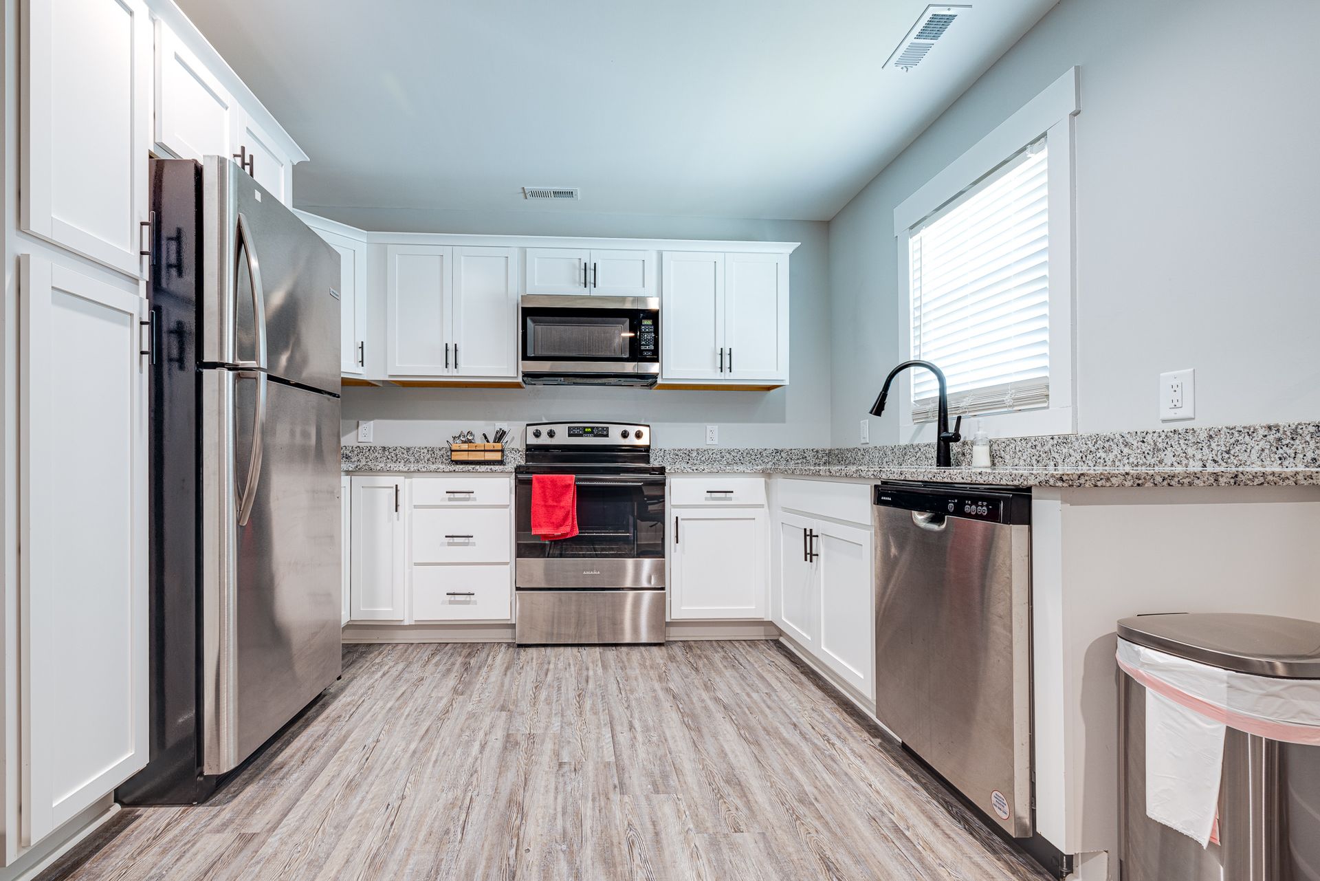A kitchen with stainless steel appliances and white cabinets