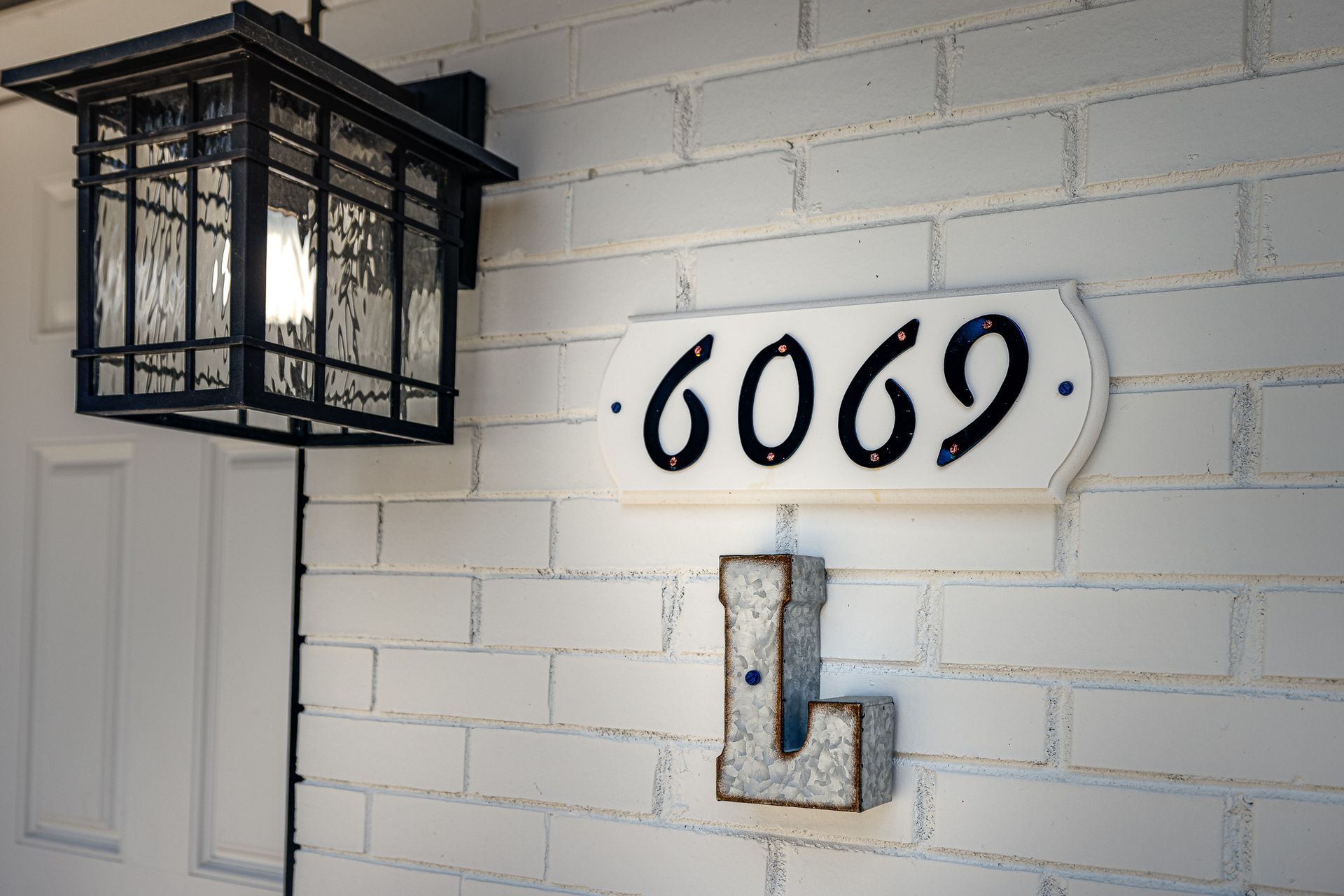 A white brick wall with a sign that says 6969 on it