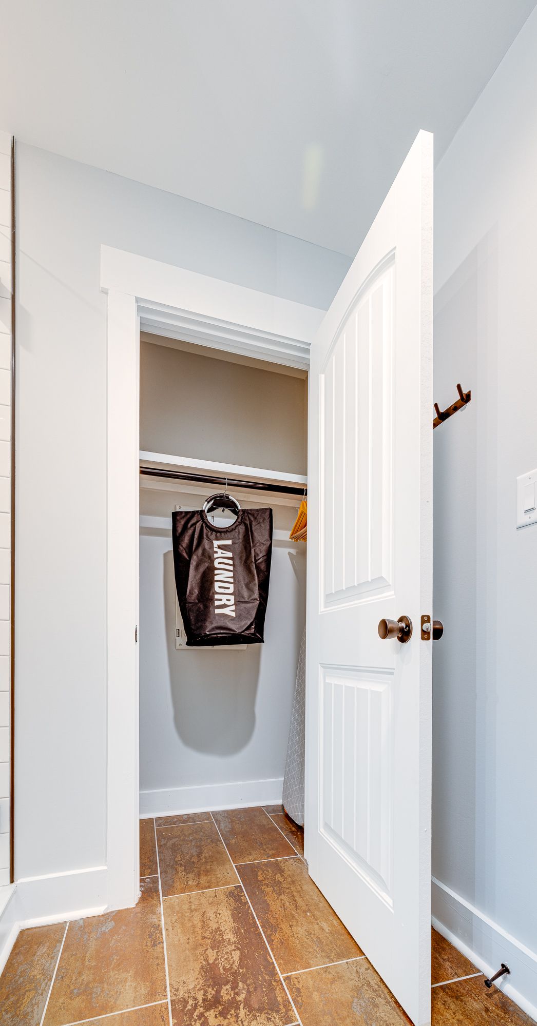 A laundry room with a bag hanging from the door.