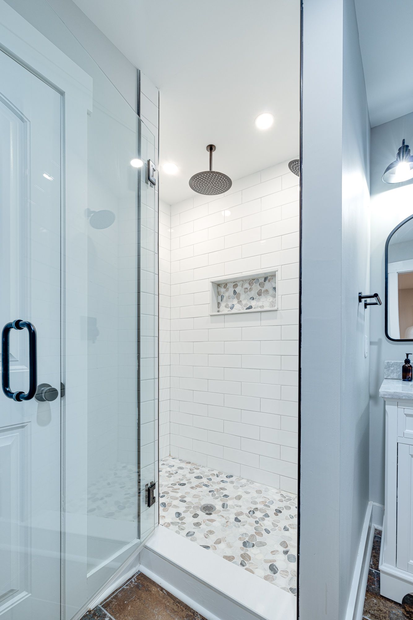 A bathroom with a walk in shower and a sink.