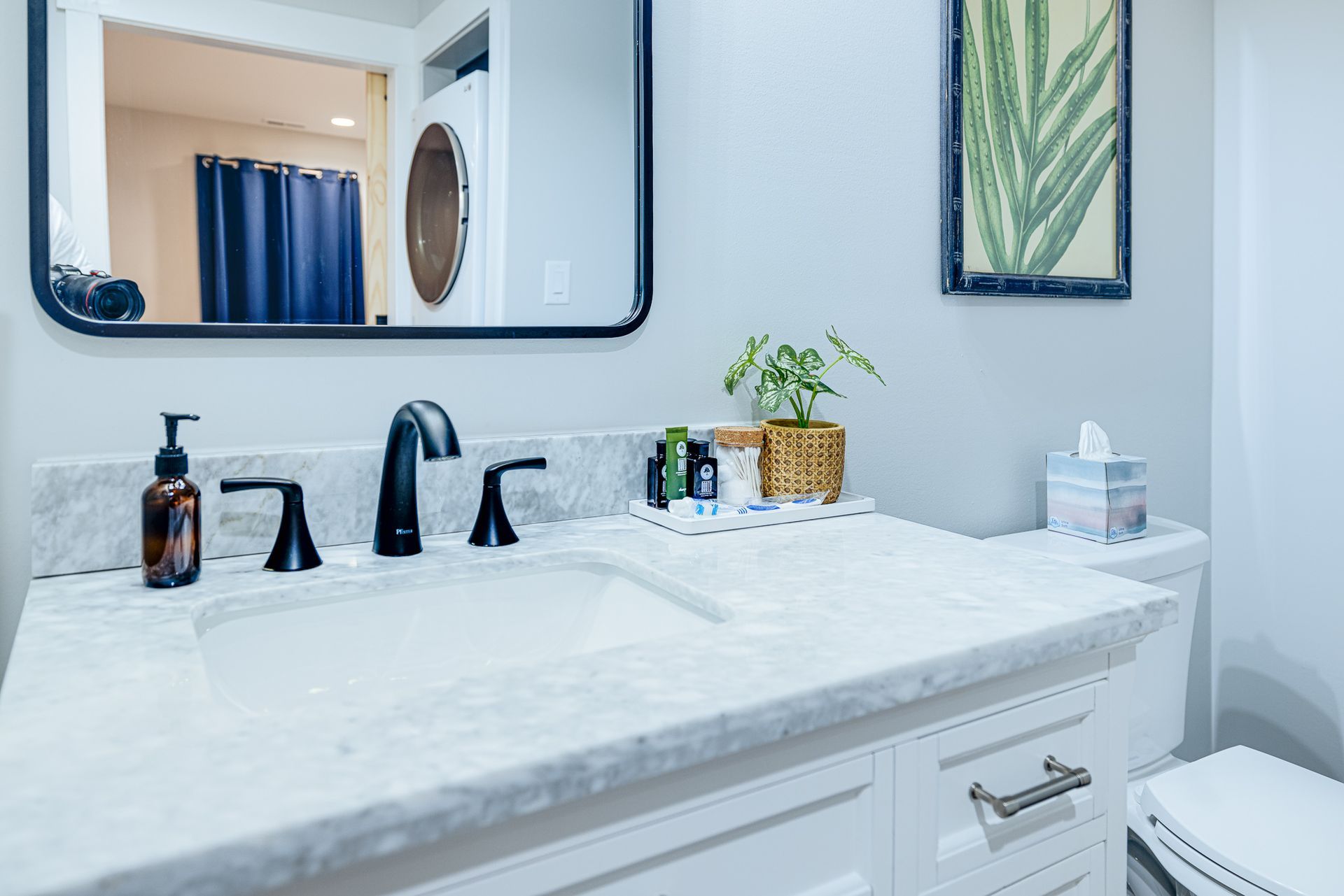 A bathroom with a sink , toilet and mirror.