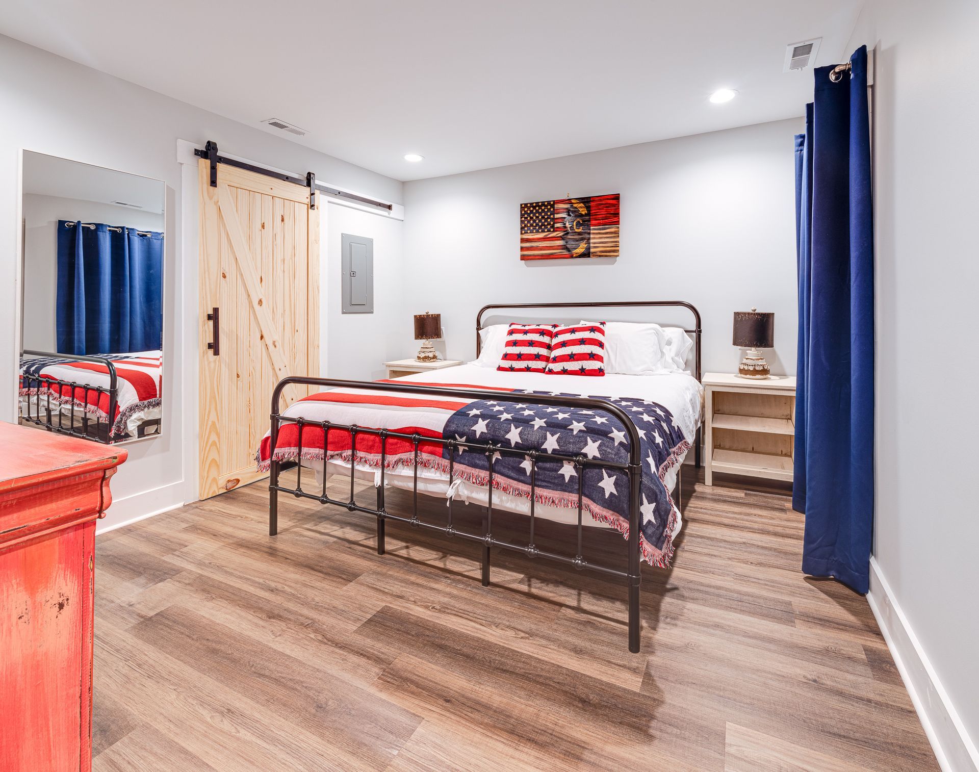 A bedroom with a king size bed and a sliding barn door.