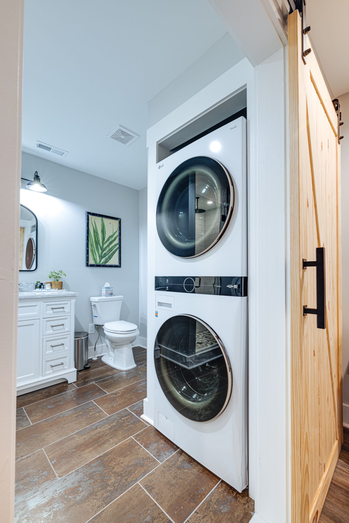 A bathroom with a washer and dryer stacked on top of each other.