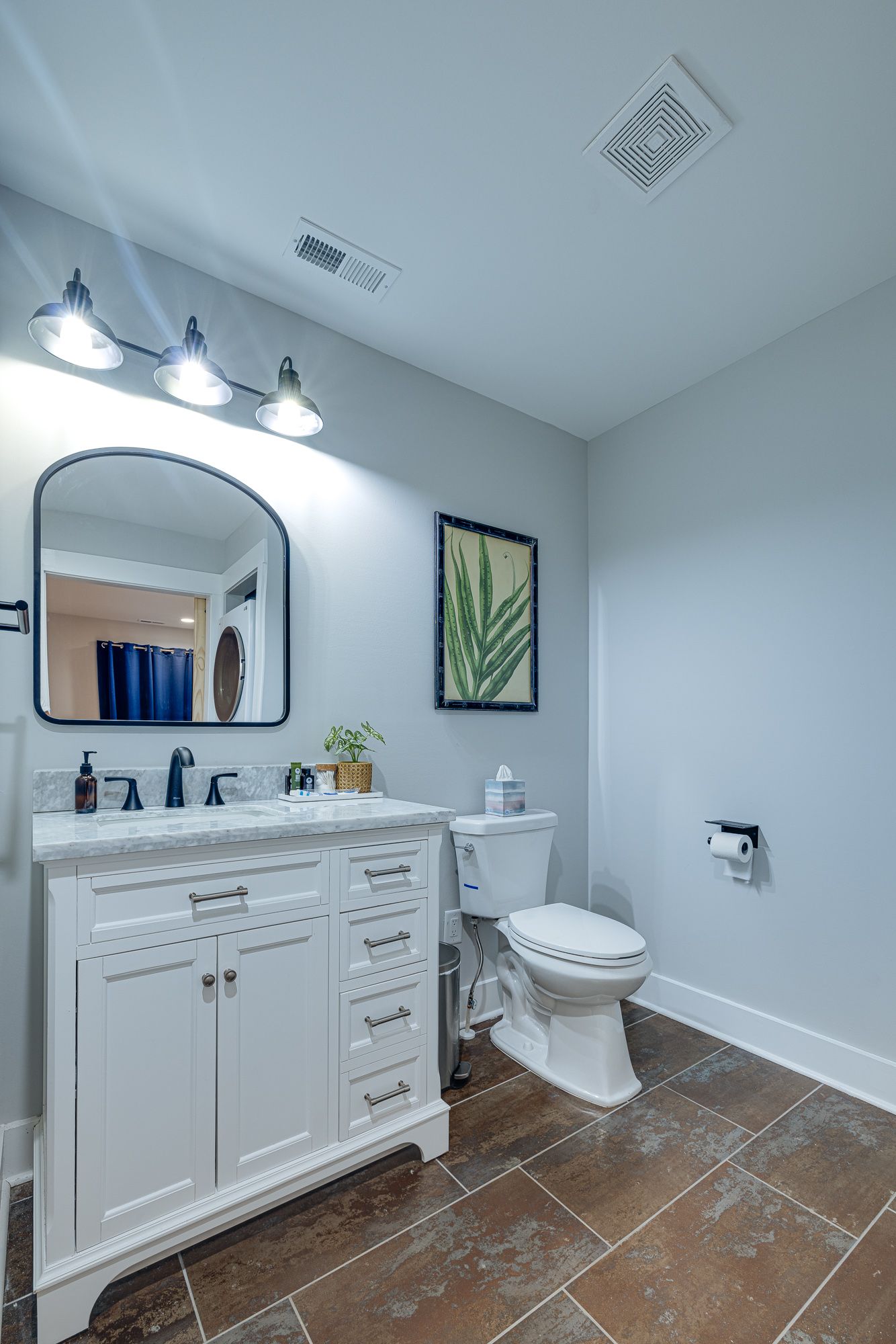 A bathroom with a sink , toilet and mirror.