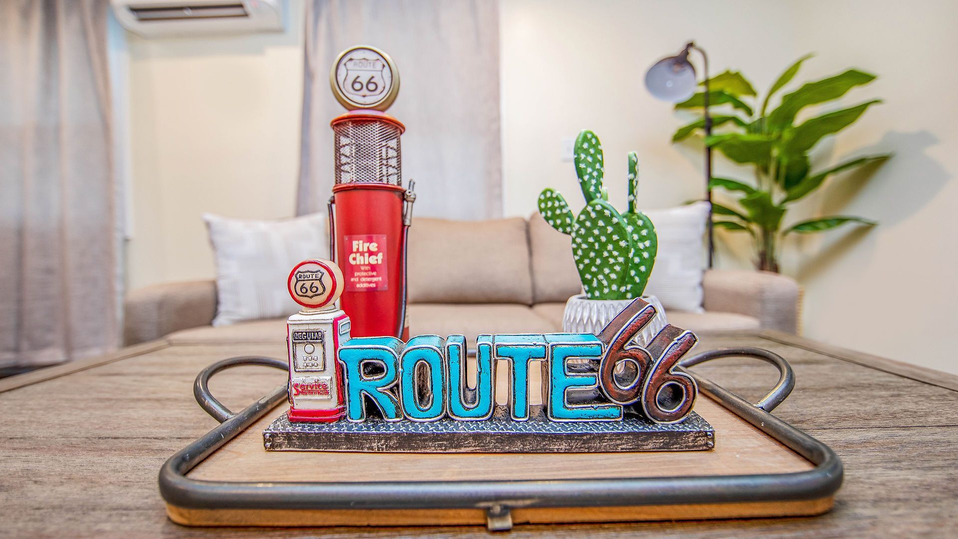 A tray with a statue of a gas pump and the word route 66 on it is on a table in a living room.