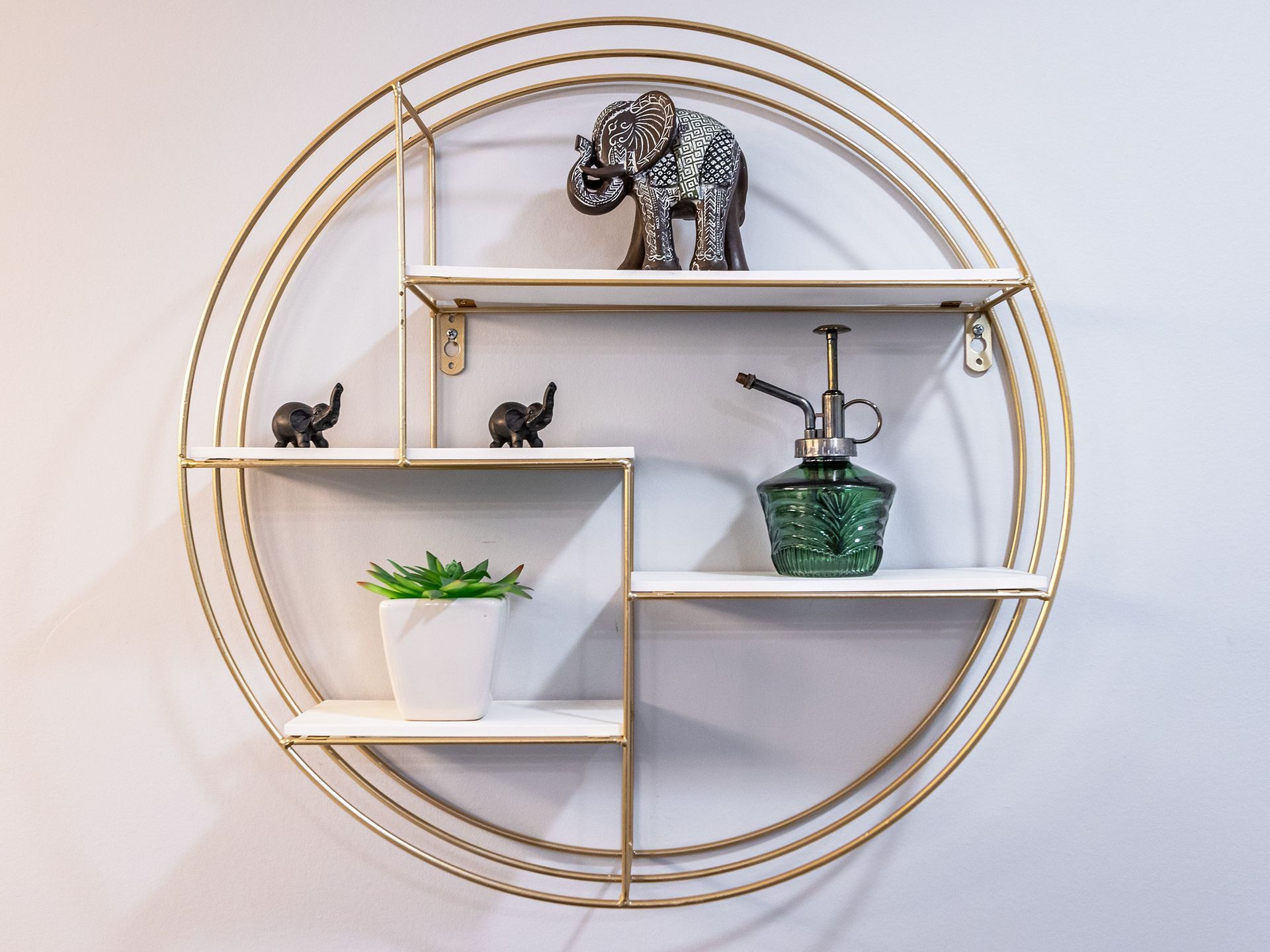 A round shelf with elephants and a plant on it