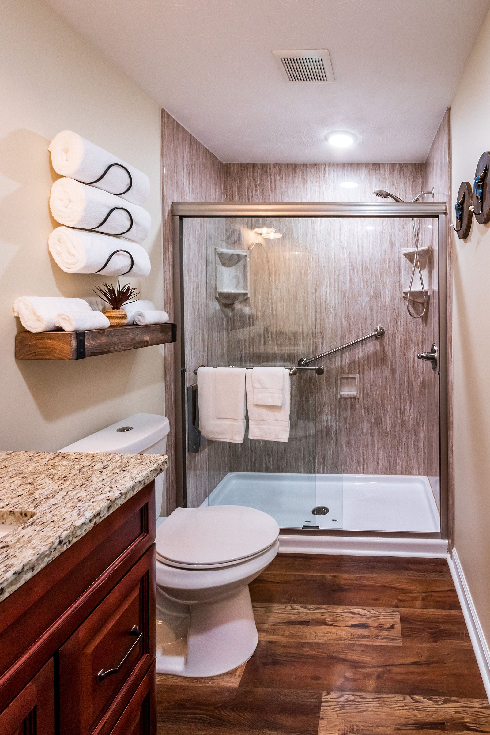 A bathroom with a toilet , sink , shower and towels.