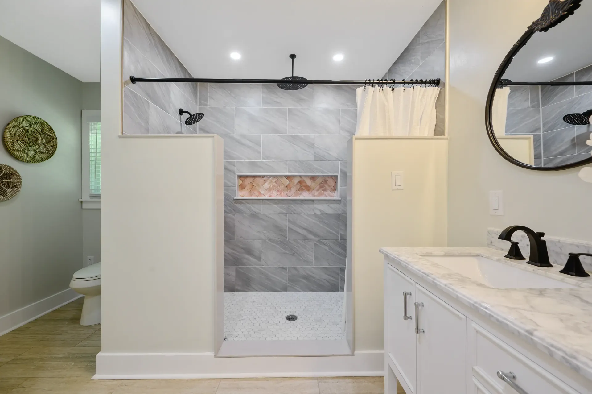 A bathroom with a walk in shower , sink and mirror.