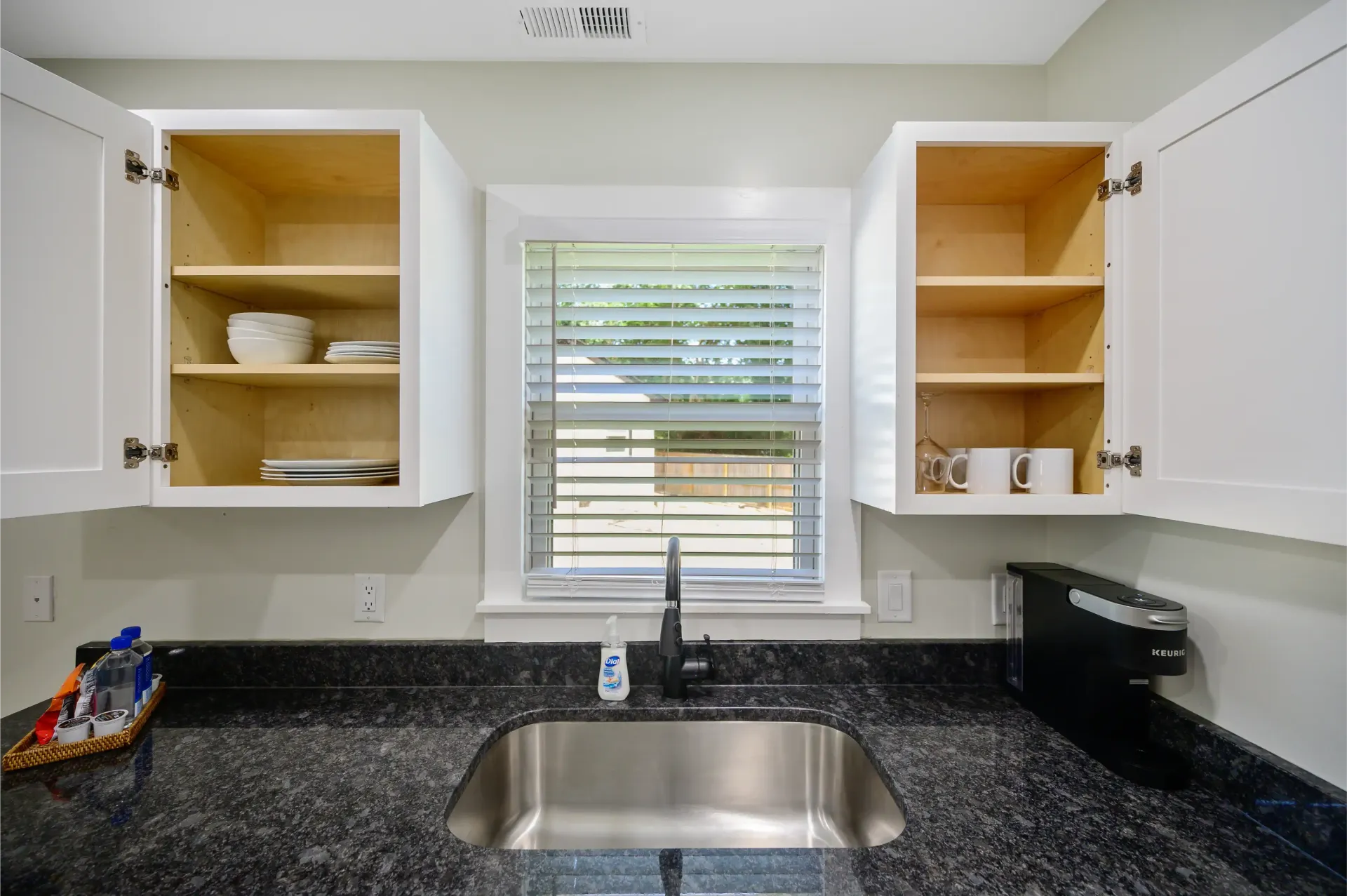 A kitchen with a sink , cabinets and a window
