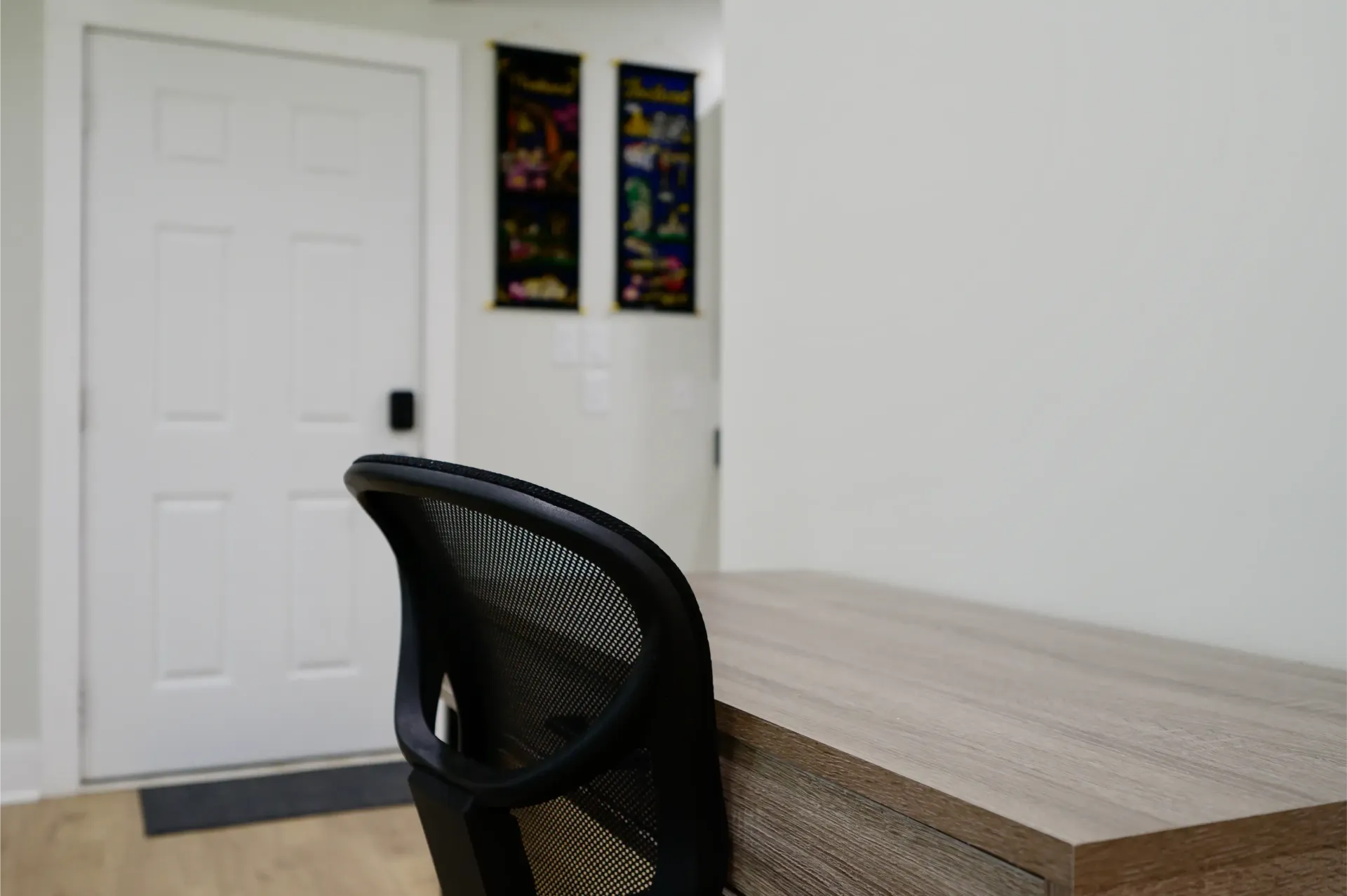 A chair is sitting at a desk in front of a door.