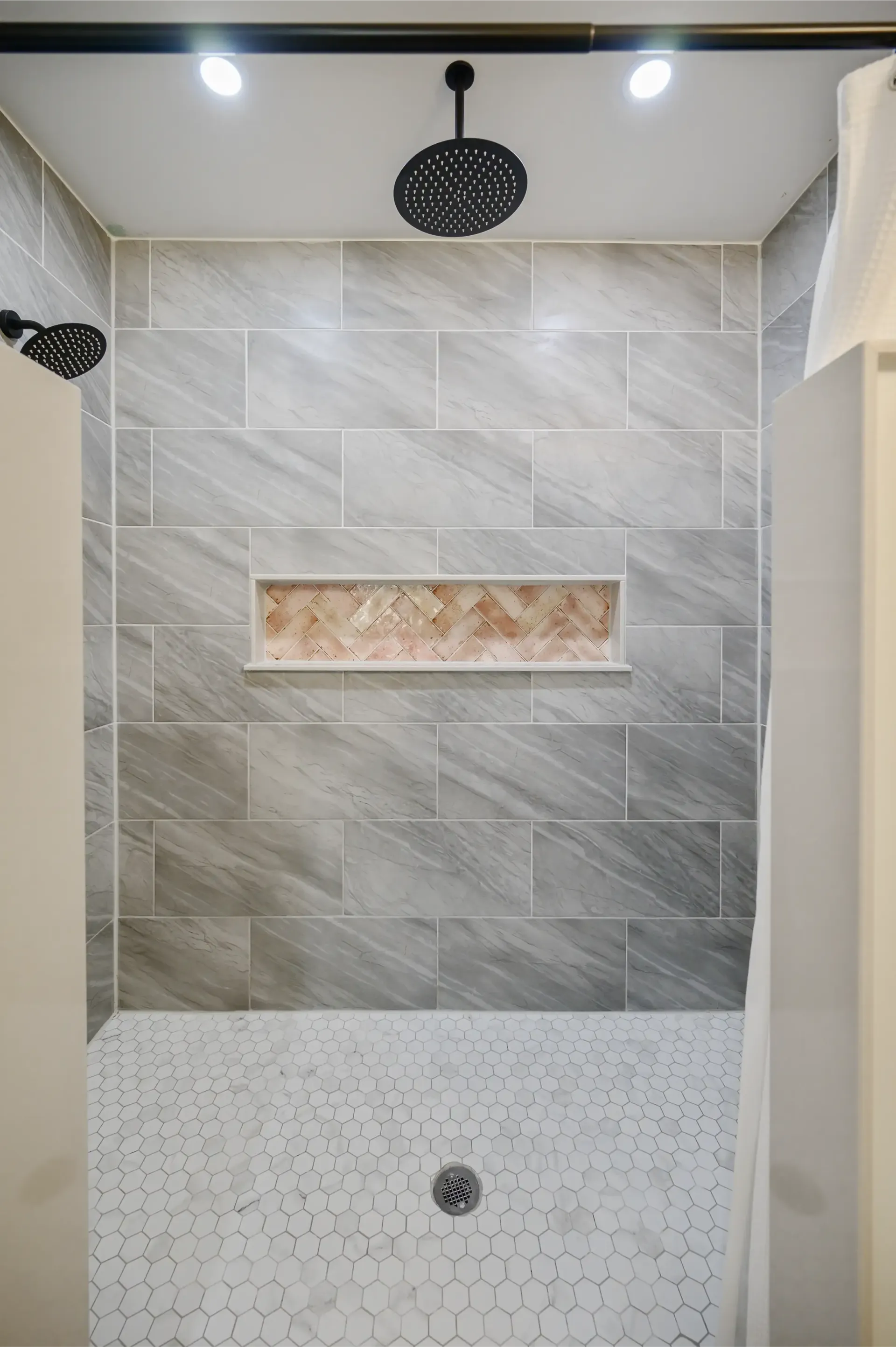 A bathroom with a walk in shower and a shower head.