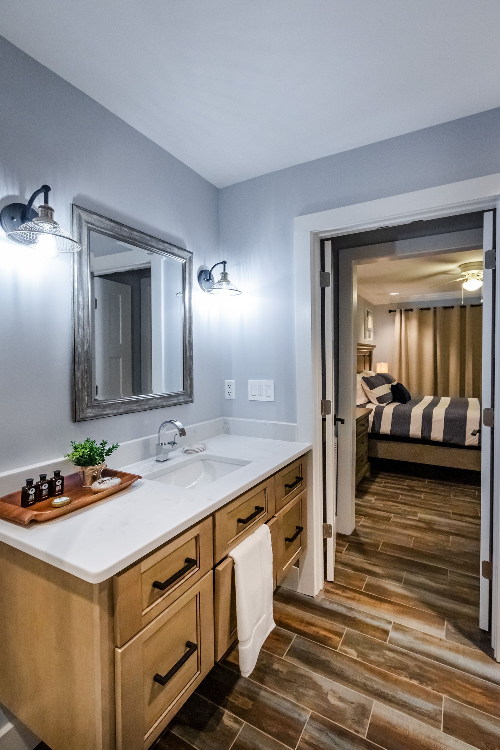 A bathroom with a sink , mirror , and wooden cabinets.