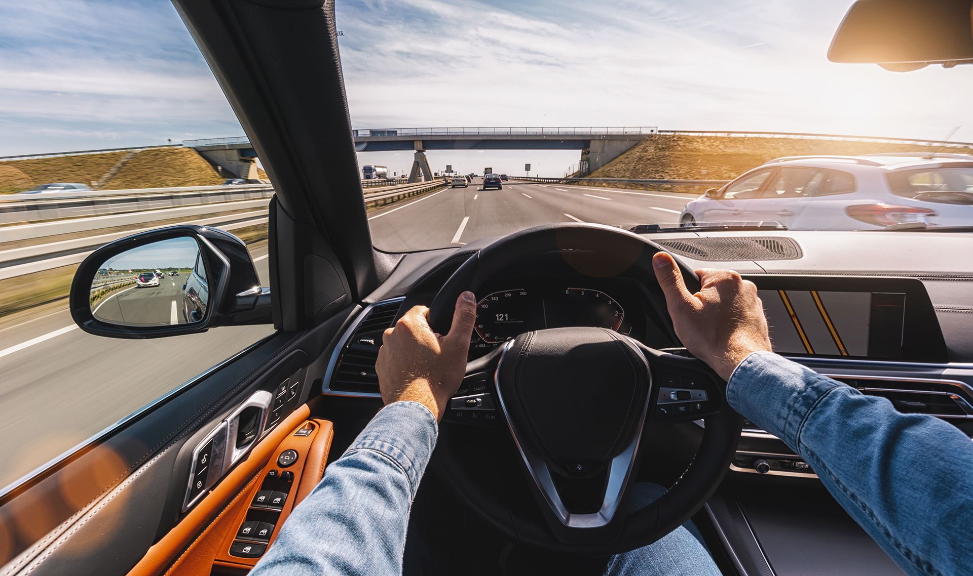 A man is driving a car on a highway.