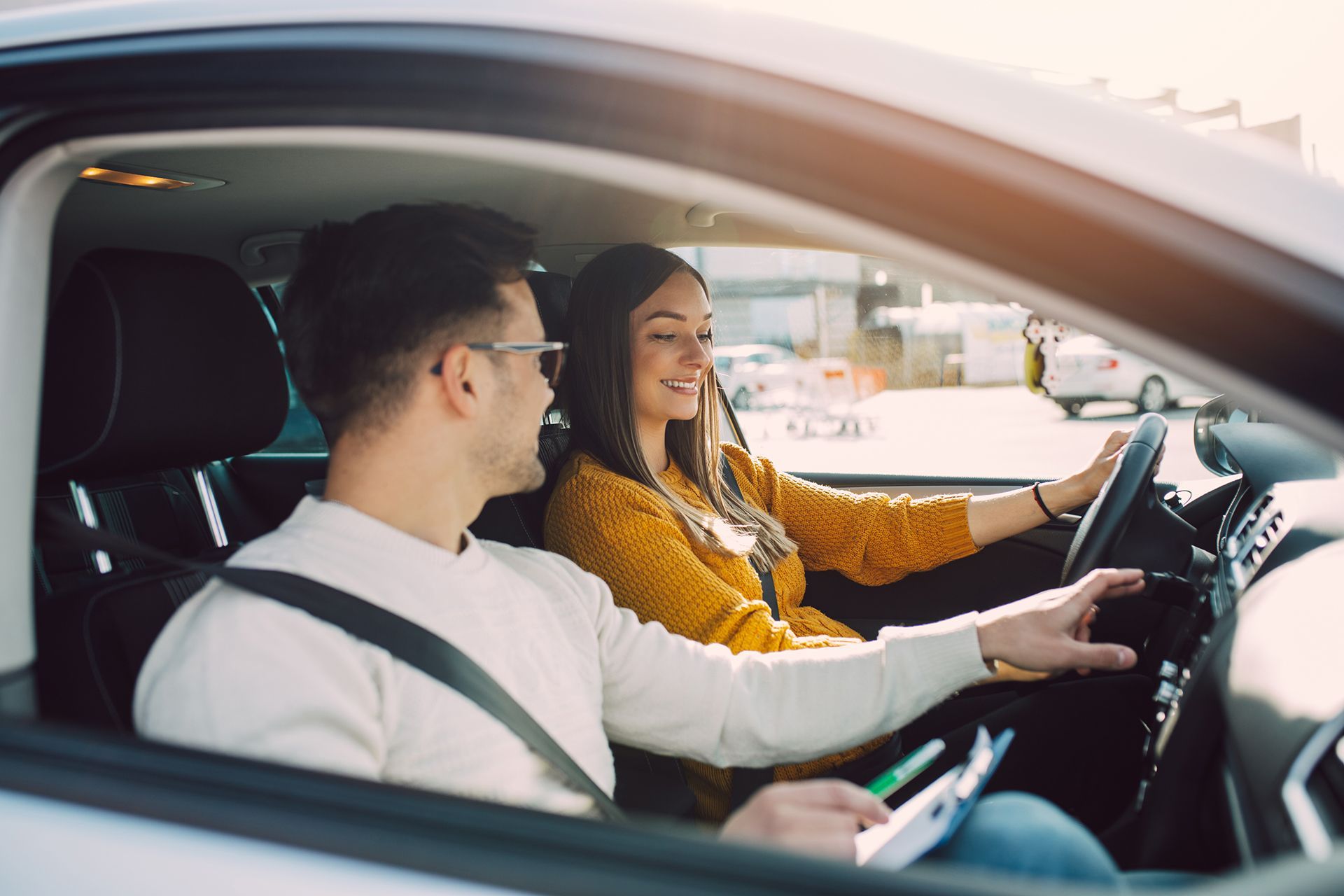 A man is teaching a woman how to drive a car.