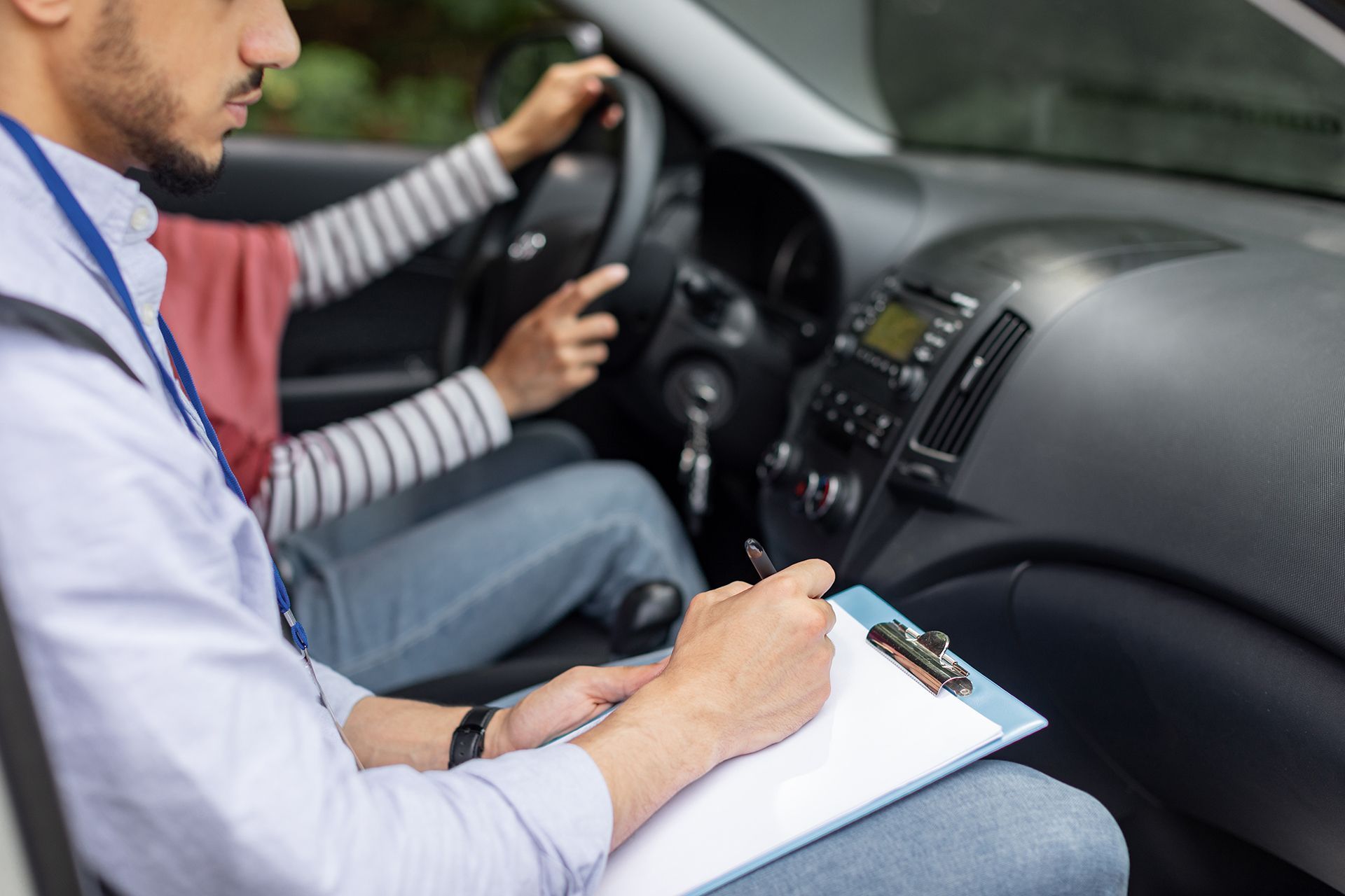 A man is teaching a woman how to drive a car.