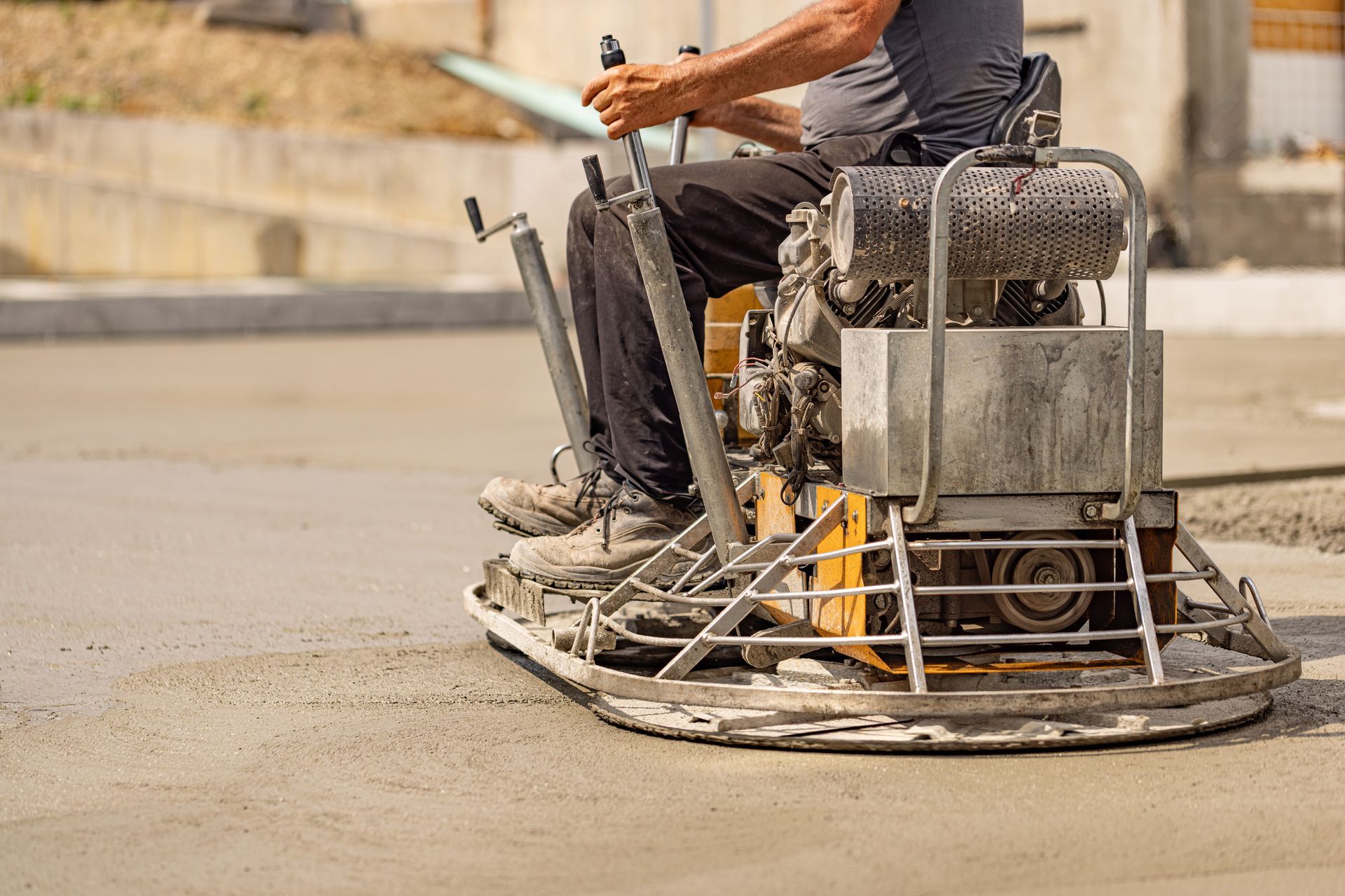 A builder on a machine used for concrete floor grinding.