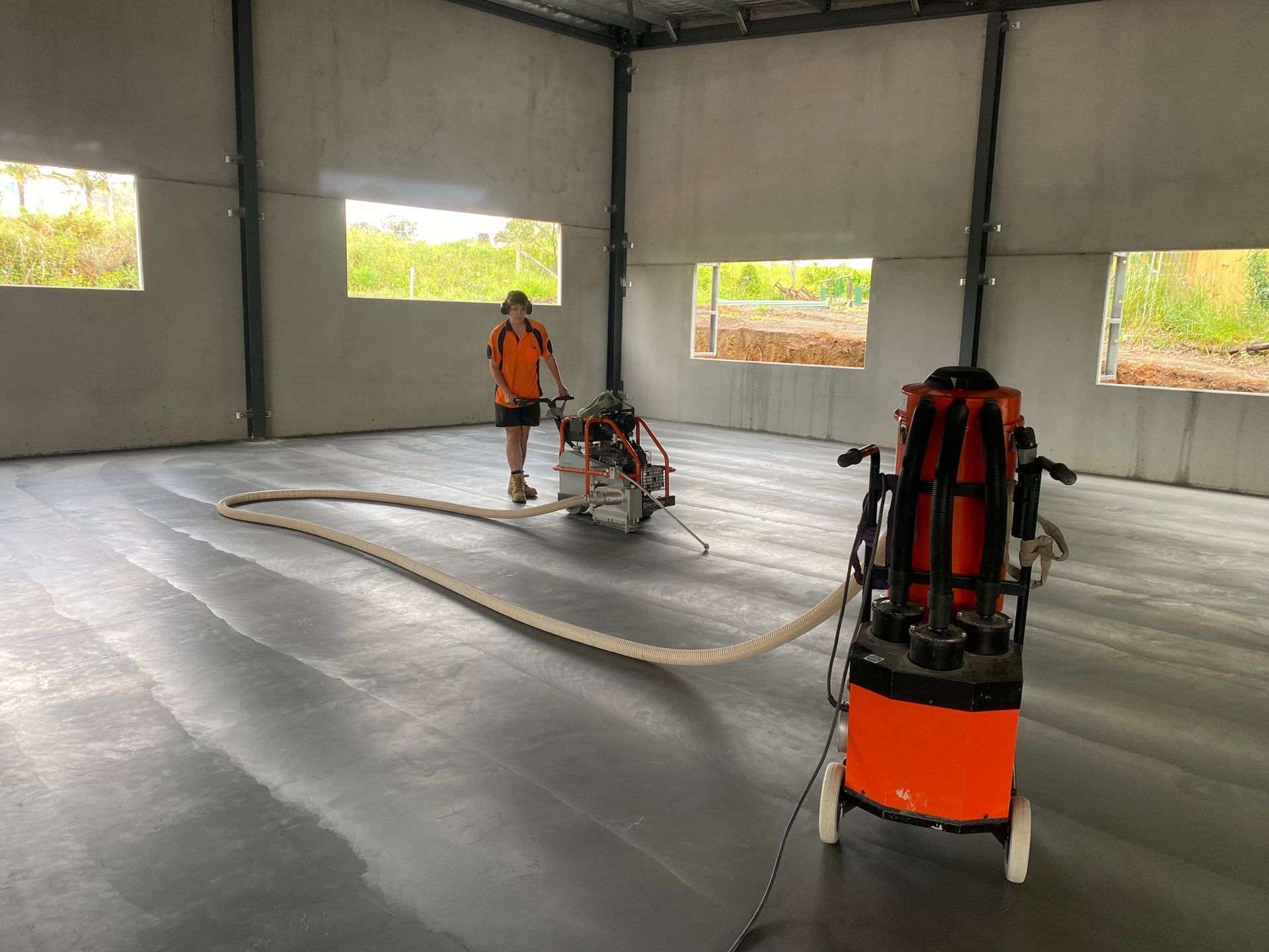 A man is using a machine to cut concrete in a building.