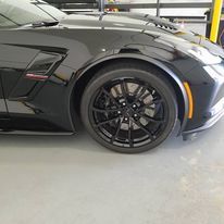 a black corvette zr1 is parked in a garage .