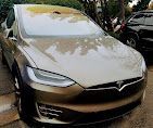 A tesla model s is parked in a driveway.