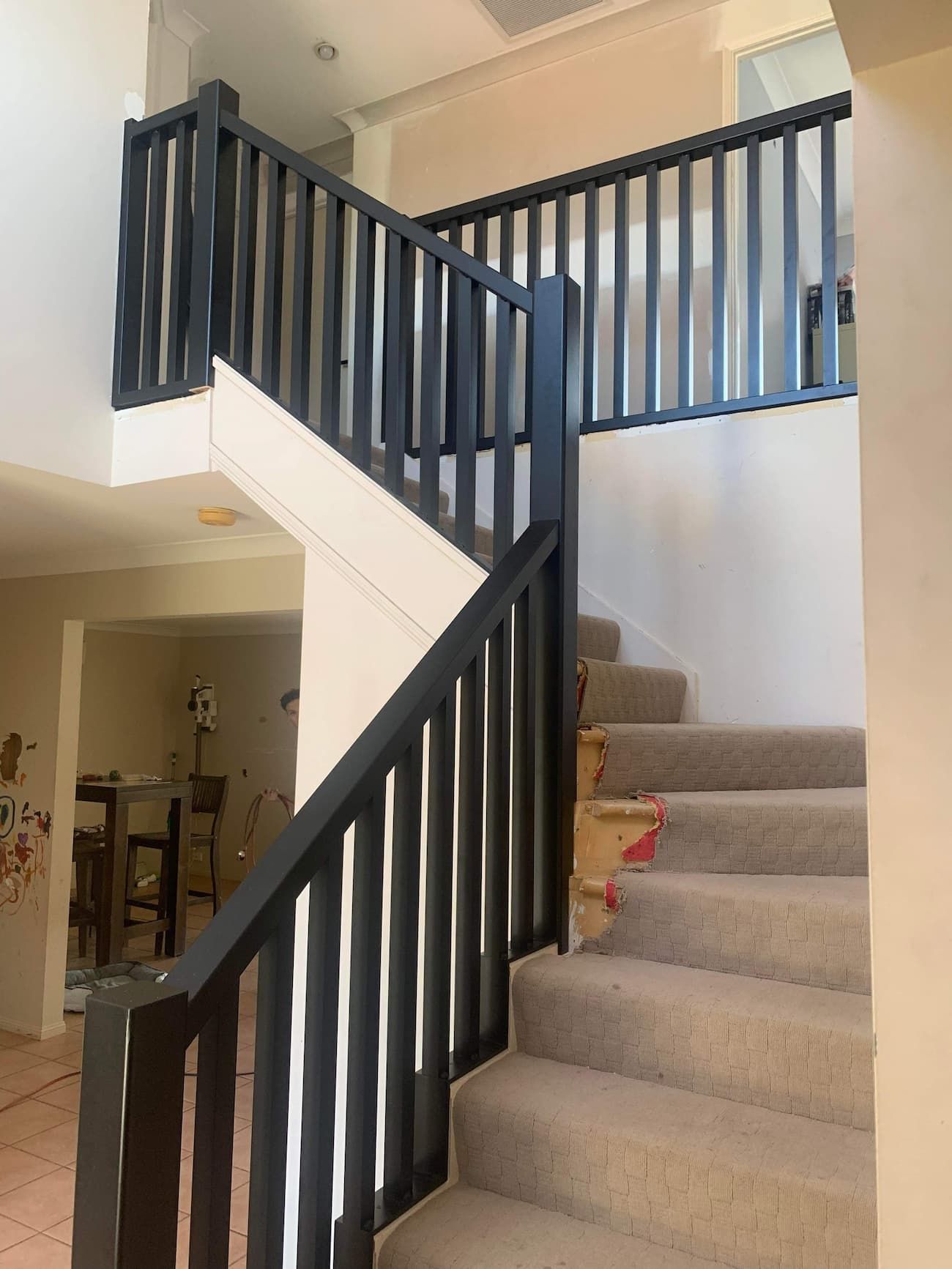 A Staircase with A Black Railing in A House — Simmweld Metal Fabrication and Welding In Tweed Heads, NSW