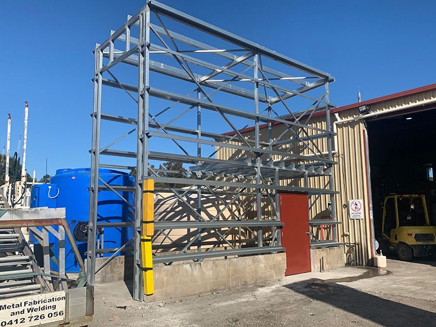 Man is Welding a Piece of Metal With a Welding Machine — Simmweld Metal Fabrication and Welding In Tweed Heads, NSW