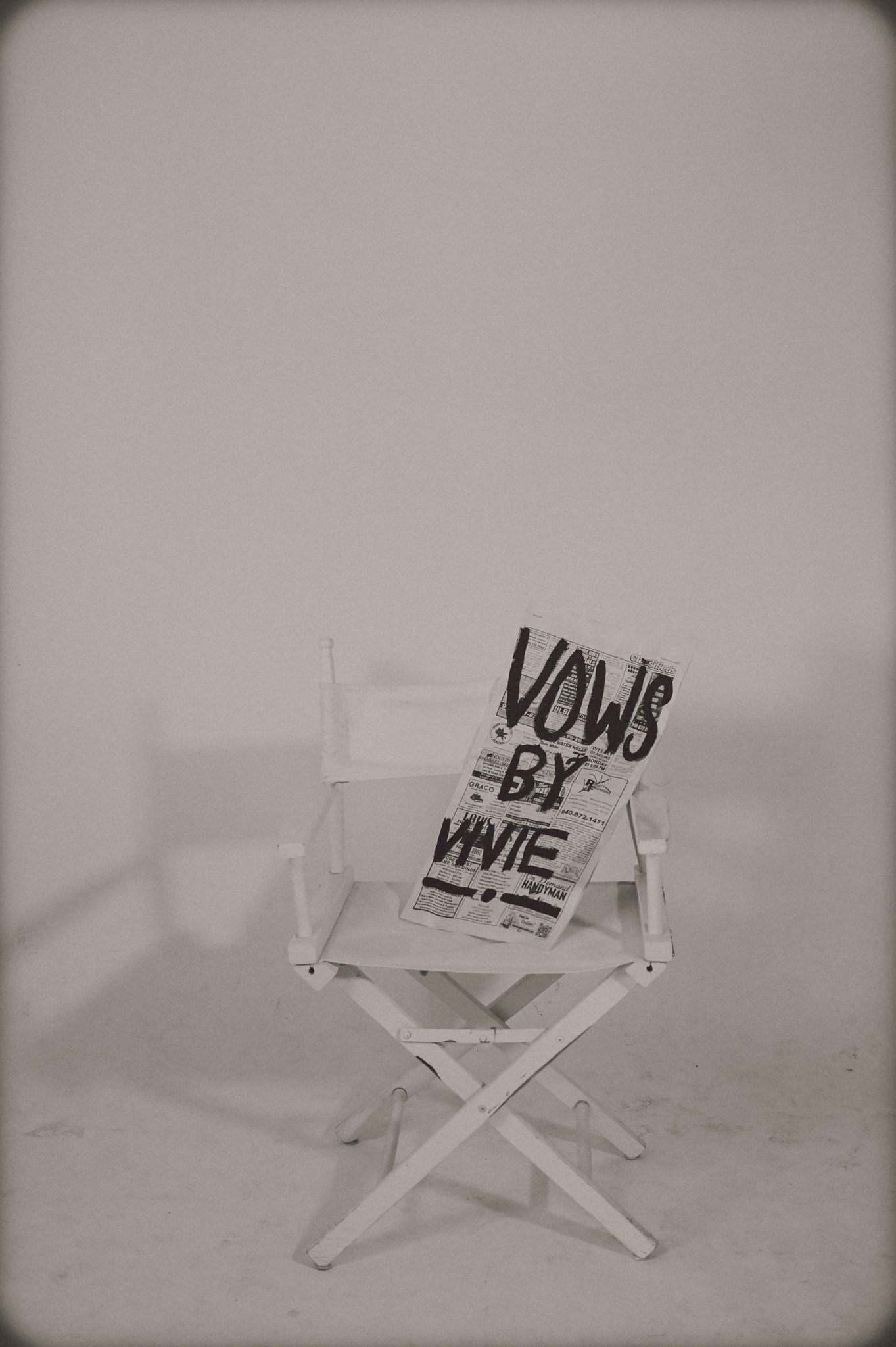 White director’s chair against a plain wall, with a bold “YOU & ME” sign on the seat