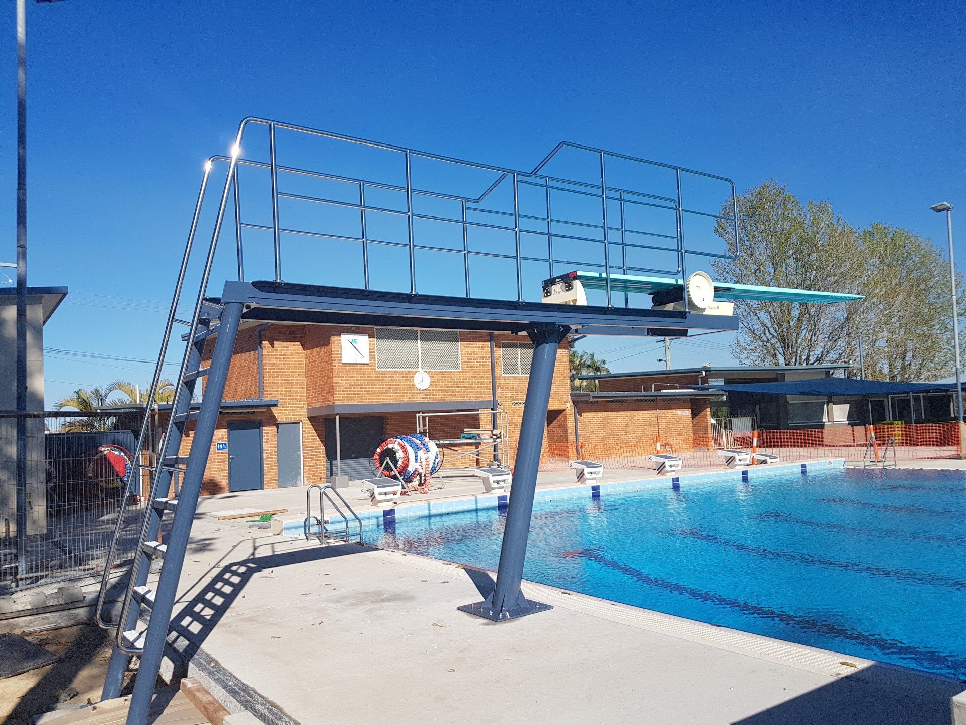 A swimming pool with a diving board on top of it