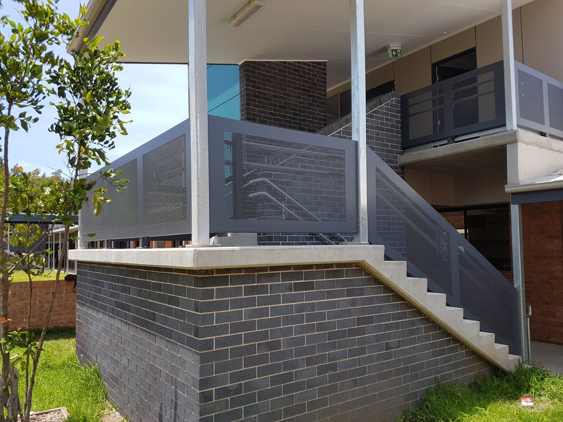 A house with a balcony and stairs on the side of it — Projects in Wauchope, NSW