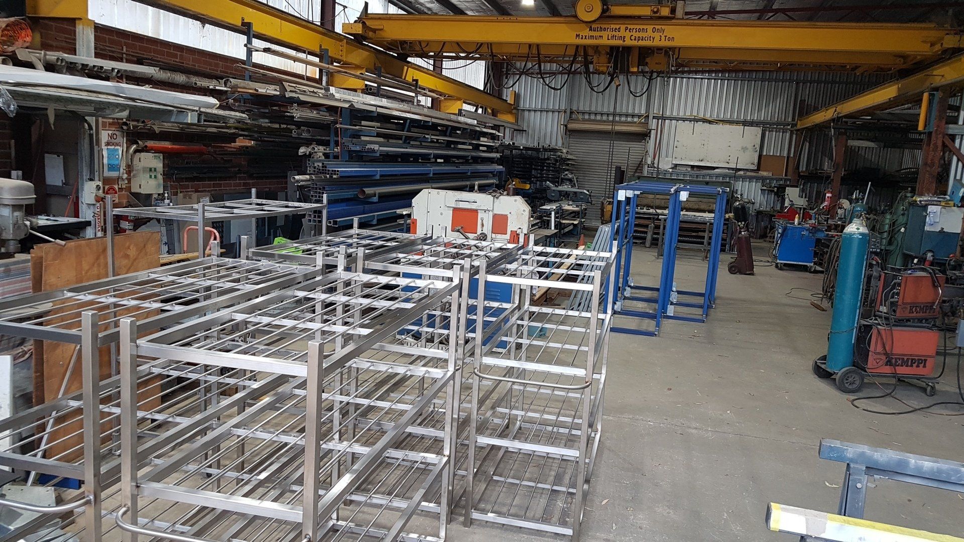 A warehouse filled with lots of metal shelves and a crane.