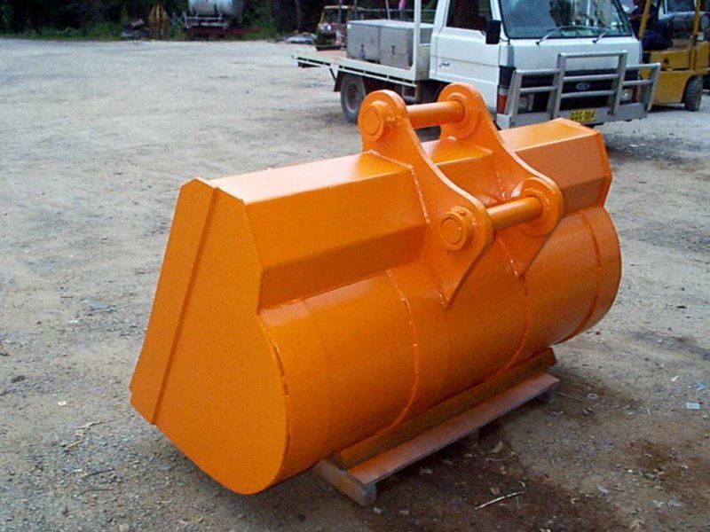 A large orange bucket is sitting on a wooden pallet
