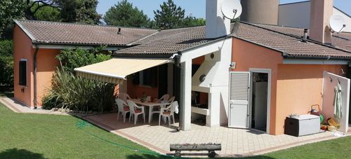 Una casa con un patio, un tavolo e delle sedie