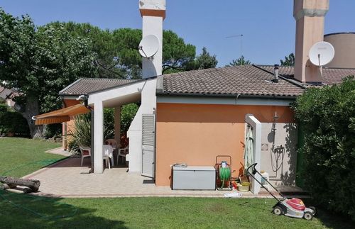 Una casa con un tosaerba davanti