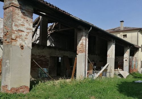 Un edificio in mattoni con un tetto ricoperto di erba