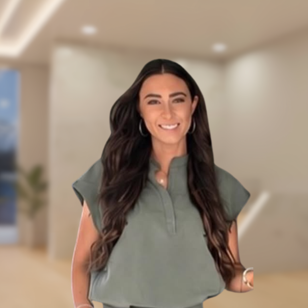Smiling woman in a green top standing in a softly lit hallway