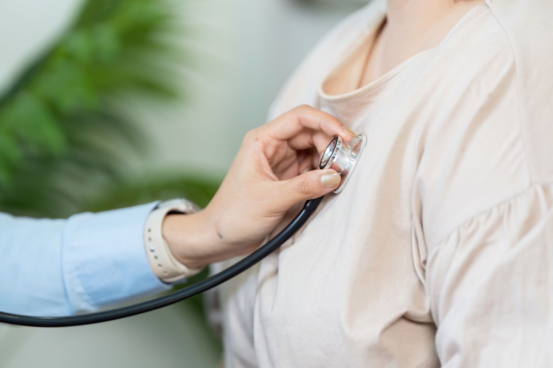 Doctor using a stethoscope to listen to a patient’s chest in a clinical setting