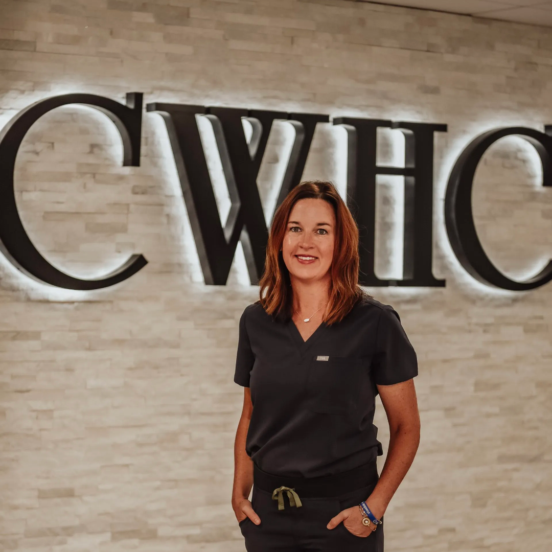 Woman in black shirt standing in front of a large CWHC wall sign