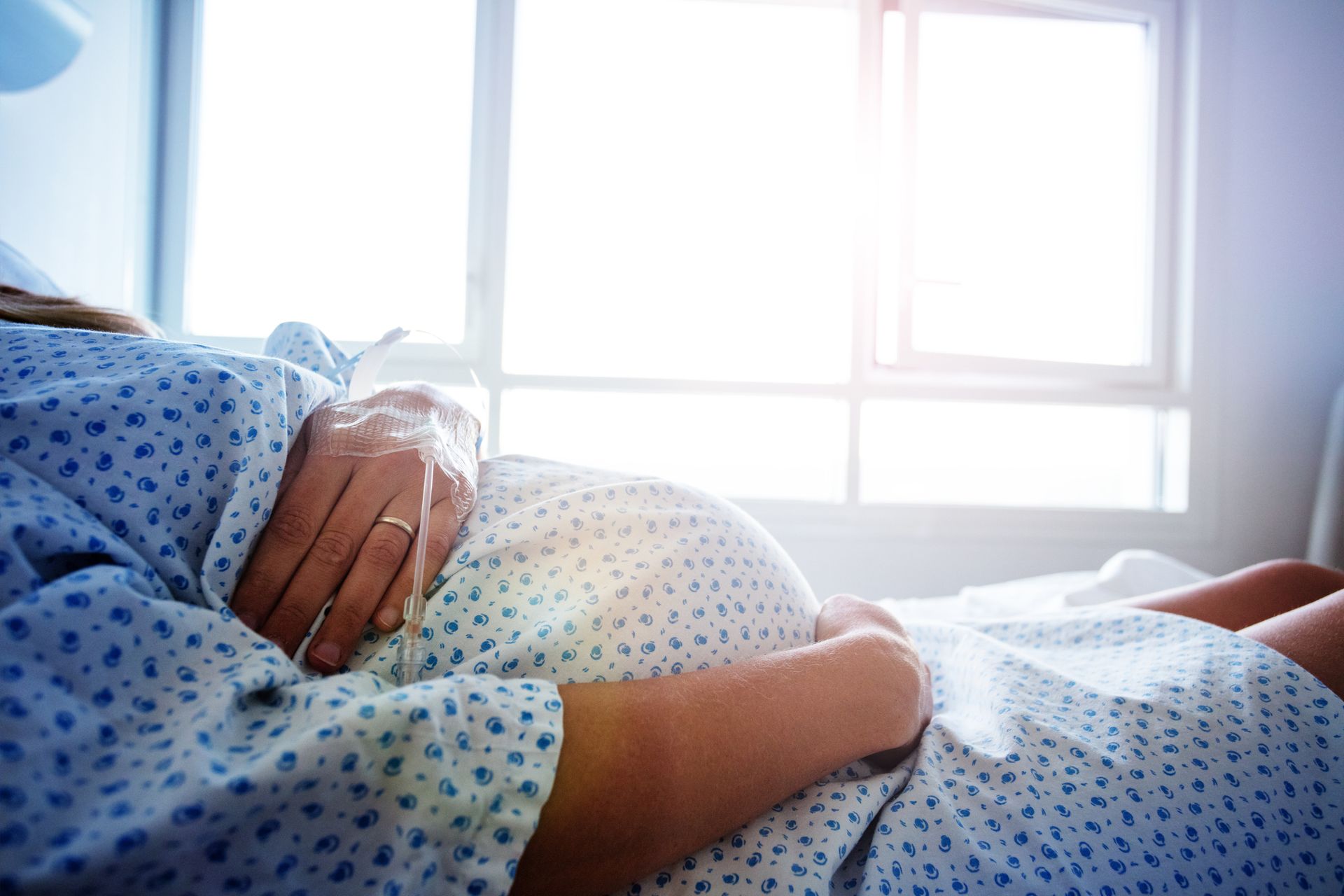Woman holding her pregnant belly in the hospital
