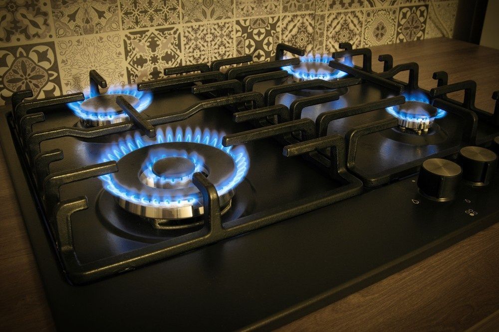 Four Stove that Has Fire Lit on It — Aqua Blue Plumbing Services in Coffs Harbour, NSW 