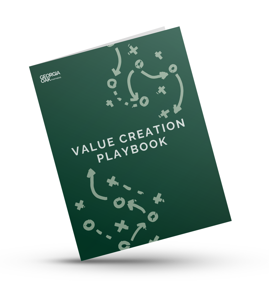A green book titled value creation playbook is sitting on a white surface.