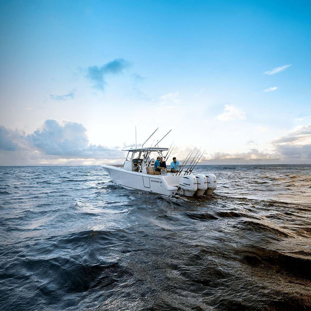 A white boat is floating on top of a large body of water.