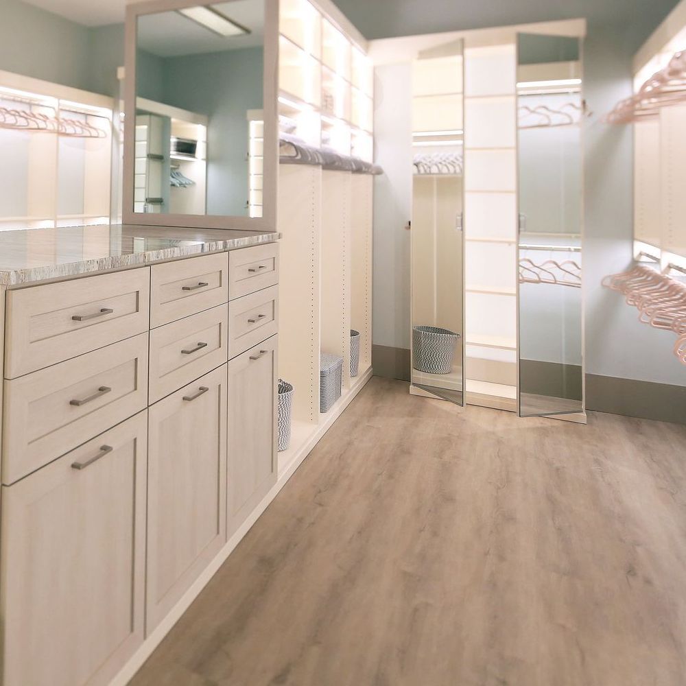 A walk in closet with drawers and a mirror